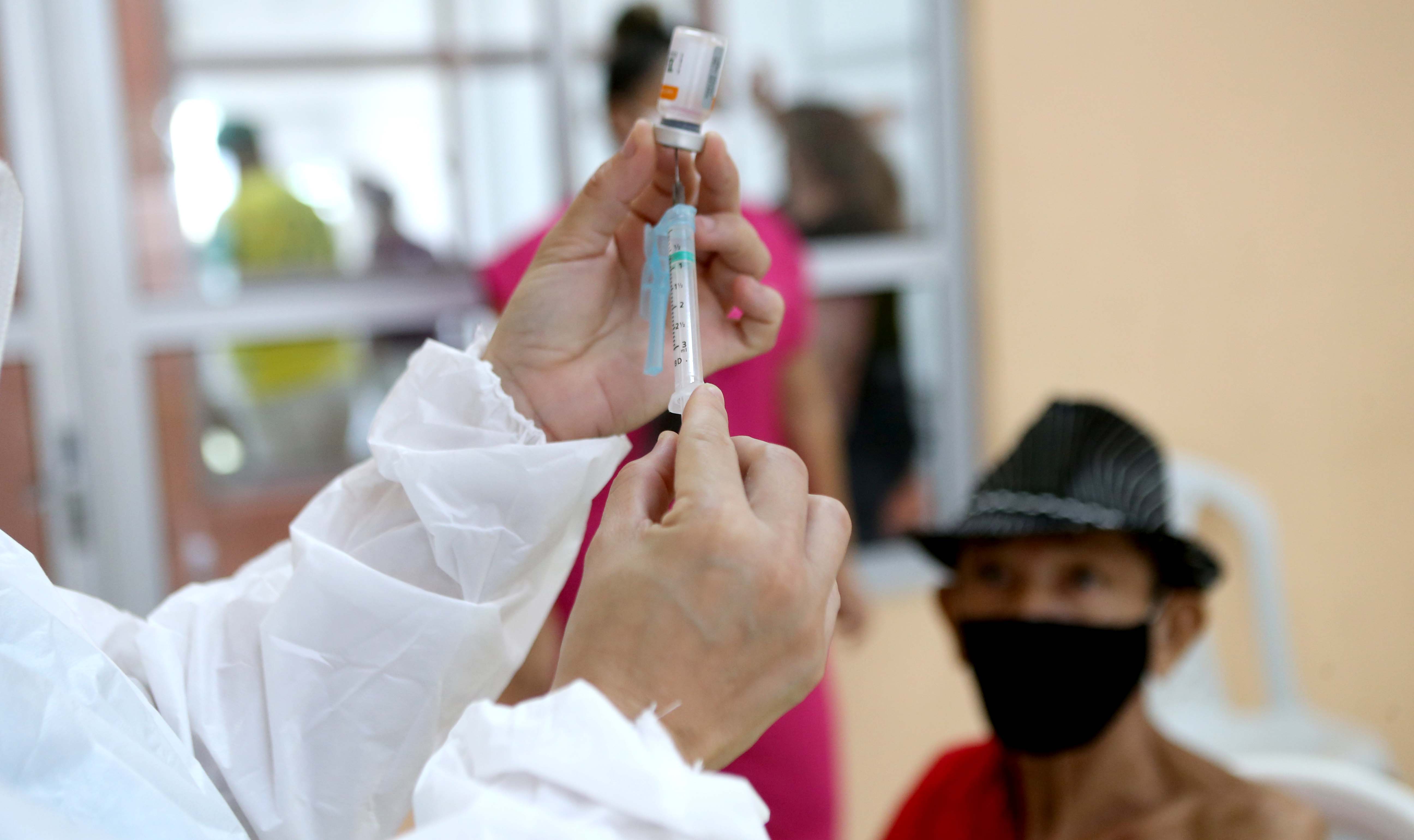 enfermeira ajusta uma seringa de vacinação